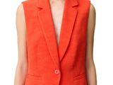 an image of a woman in an orange suit with a handbag