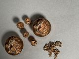 trois boutons en or et une chaîne en or posés sur une table