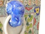 a blue elephant on the handle of a decorative box