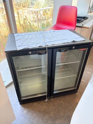 a small table with a red chair next to a glass door