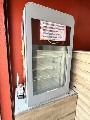 une porte vitrée sur laquelle est accrochée une affiche, dans un magasin