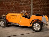 a small orange car parked in front of a brick wall