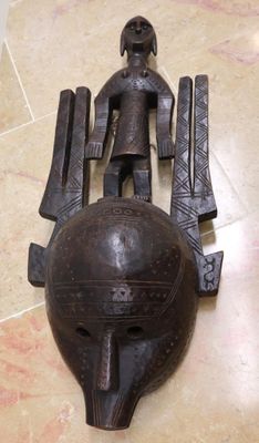 une sculpture en bois représentant un homme sur une boule