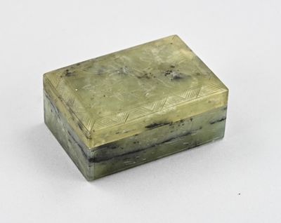 une image représentant une boîte verte munie d'une poignée, posée sur une surface blanche