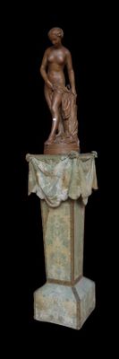 une statue représentant un homme sur un socle, sur fond noir