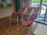 many chairs in a room with a windmill painting on the wall