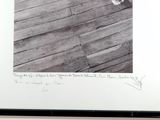a black and white photo of a dog standing on a wooden floor