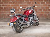 a red motorcycle that is parked in front of a brick wall