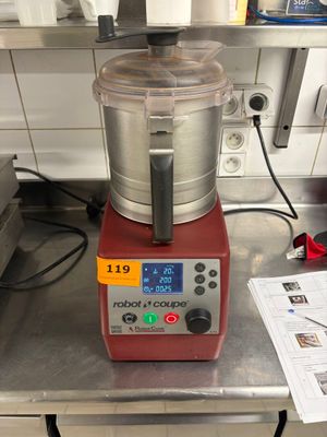 un mixeur rouge posé sur une table dans une cuisine