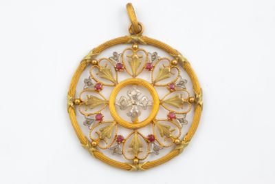 un gros plan d'un pendentif en or et diamants sur fond blanc