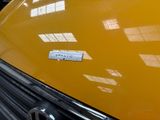a close up of a yellow car with a sticker on it