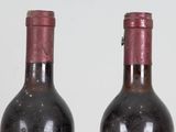 two bottles of wine sitting next to each other on a table