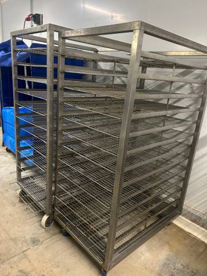 une photo représentant un présentoir métallique sur lequel sont disposés plusieurs plateaux de nourriture