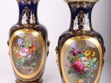 une paire de vases bleus ornés de fleurs peintes, posés sur une table