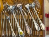 silverware in a brown case with red handles and spoons in it