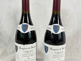 two bottles of wine sitting on top of a table next to each other