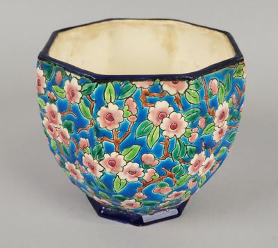 un bol bleu orné de fleurs roses et de feuilles vertes