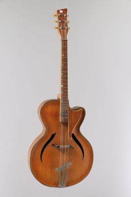 an old guitar hanging from the ceiling in a room