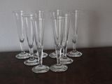 four empty wine glasses sitting on top of a table next to a wall
