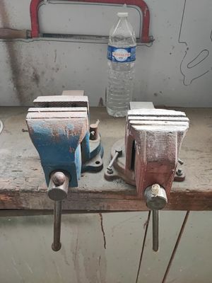 deux étaux sur un établi, avec une bouteille d'eau en arrière-plan