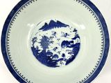 a blue and white plate with a mountain scene on it