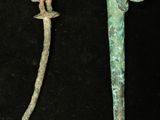 two old metal items on a black surface with a black background