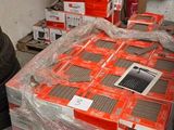 un homme qui se tient à côté d'un tas d'appareils électroniques