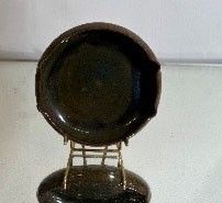 a black plate sitting on top of a metal chair