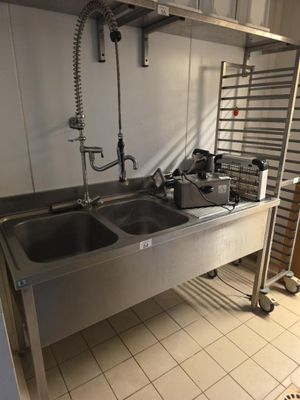 une cuisine équipée d'un évier et d'une échelle