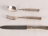 three forks, a spoon, and a knife on a table