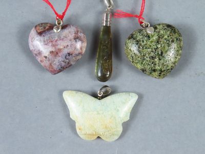trois types de pierres différents et un papillon suspendu à un fil rouge