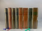 six books are lined up in a row on a white surface
