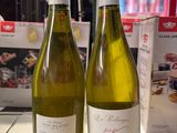 deux bouteilles de vin posées sur une table l'une à côté de l'autre
