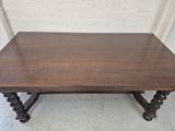 a brown table with a wooden top sitting on top of a cement floor