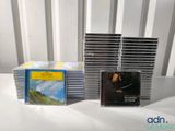 a lot of cds on a table with a white chair