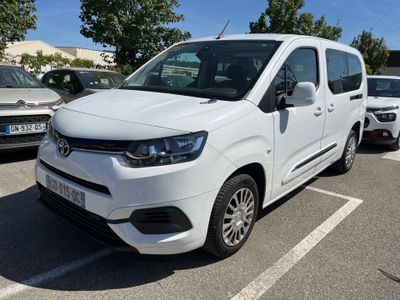 une camionnette blanche garée dans un parking à côté d'autres voitures