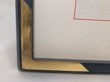 framed picture of a black and gold frame with a picture of a red square on it