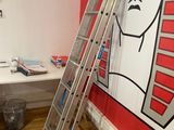a ladder leaning up against a wall with a painting of a man on it