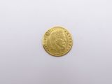 a close up of a gold coin on a white surface