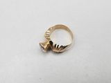 a close up of a gold ring on a white surface