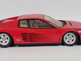 red model of a car on a white surface with a white background