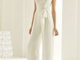 a woman in a white jumpsuit standing in a white room
