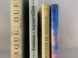 trois livres posés l'un à côté de l'autre sur une table