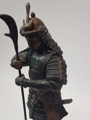 a statue of a man in armor holding a staff