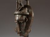 une sculpture en bronze représentant un homme barbu coiffé d'un chapeau