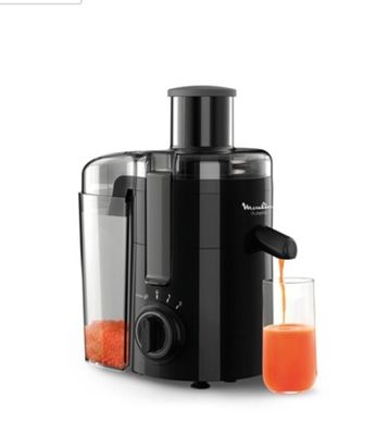 une photo d'un extracteur de jus avec un verre de jus d'orange à côté