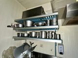 many pots and pans on the shelves in the kitchen
