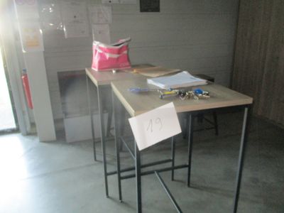 une petite table sur laquelle est posé un panneau, dans une pièce