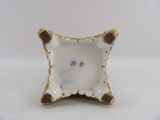 a small white plate with a brown and white design