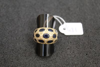 an image of a black and gold ring with a tag on it
